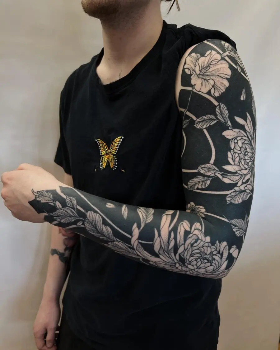 Intricate floral and butterfly sleeve tattoo design