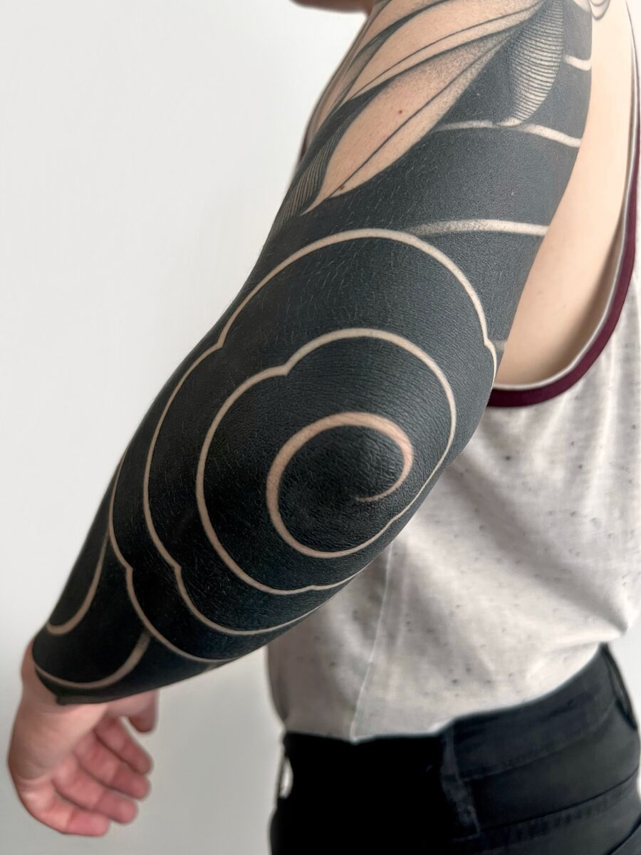 Elegant swirls in striking black ink tattoo
