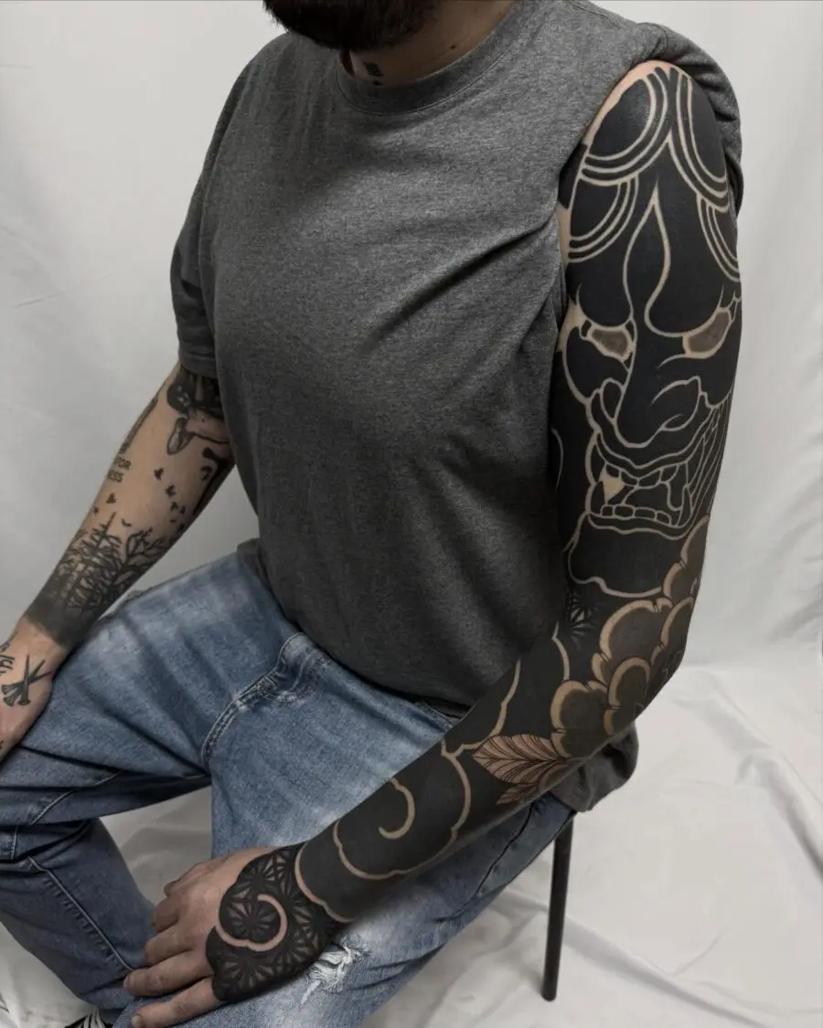 Intricate black sleeve tattoo on male arm