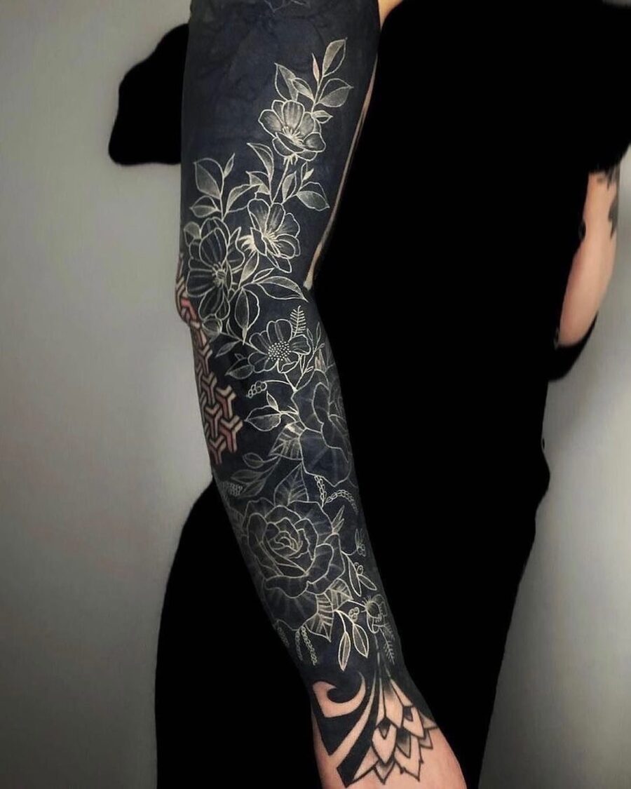 Intricate floral design on a black sleeve tattoo