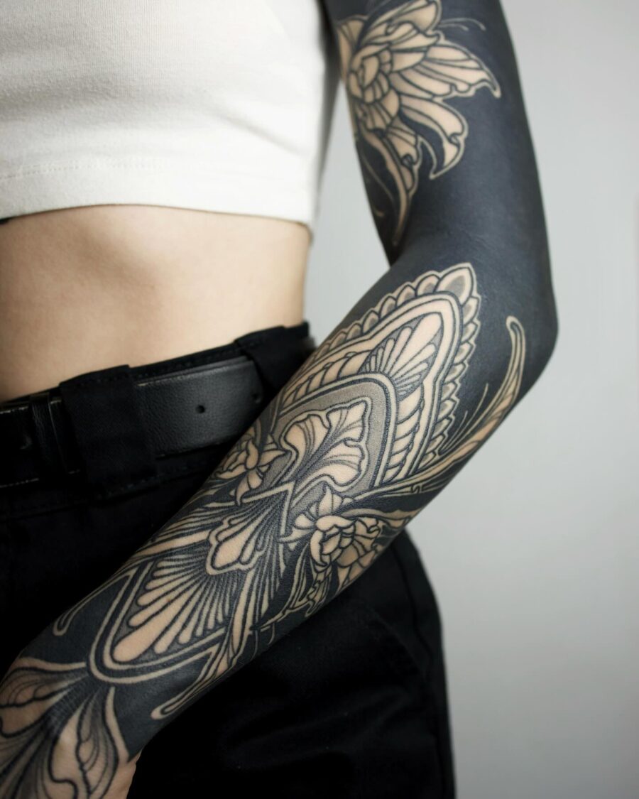 Intricate floral design in black sleeve tattoo