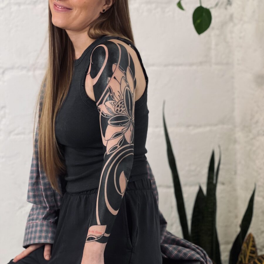 Elegant floral black sleeve tattoo on arm
