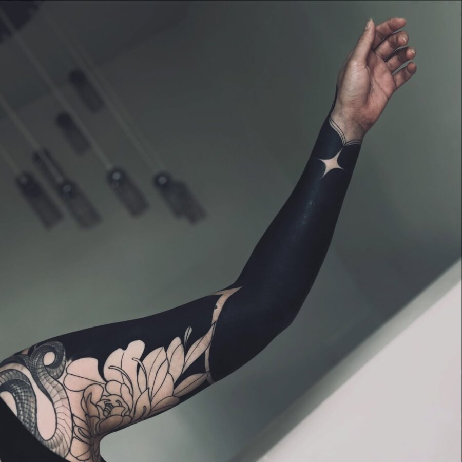 Intricate black sleeve tattoo with floral elements