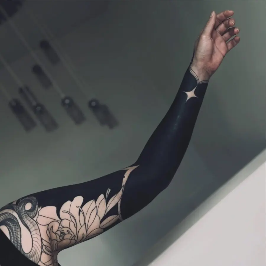 Intricate black sleeve tattoo with floral elements