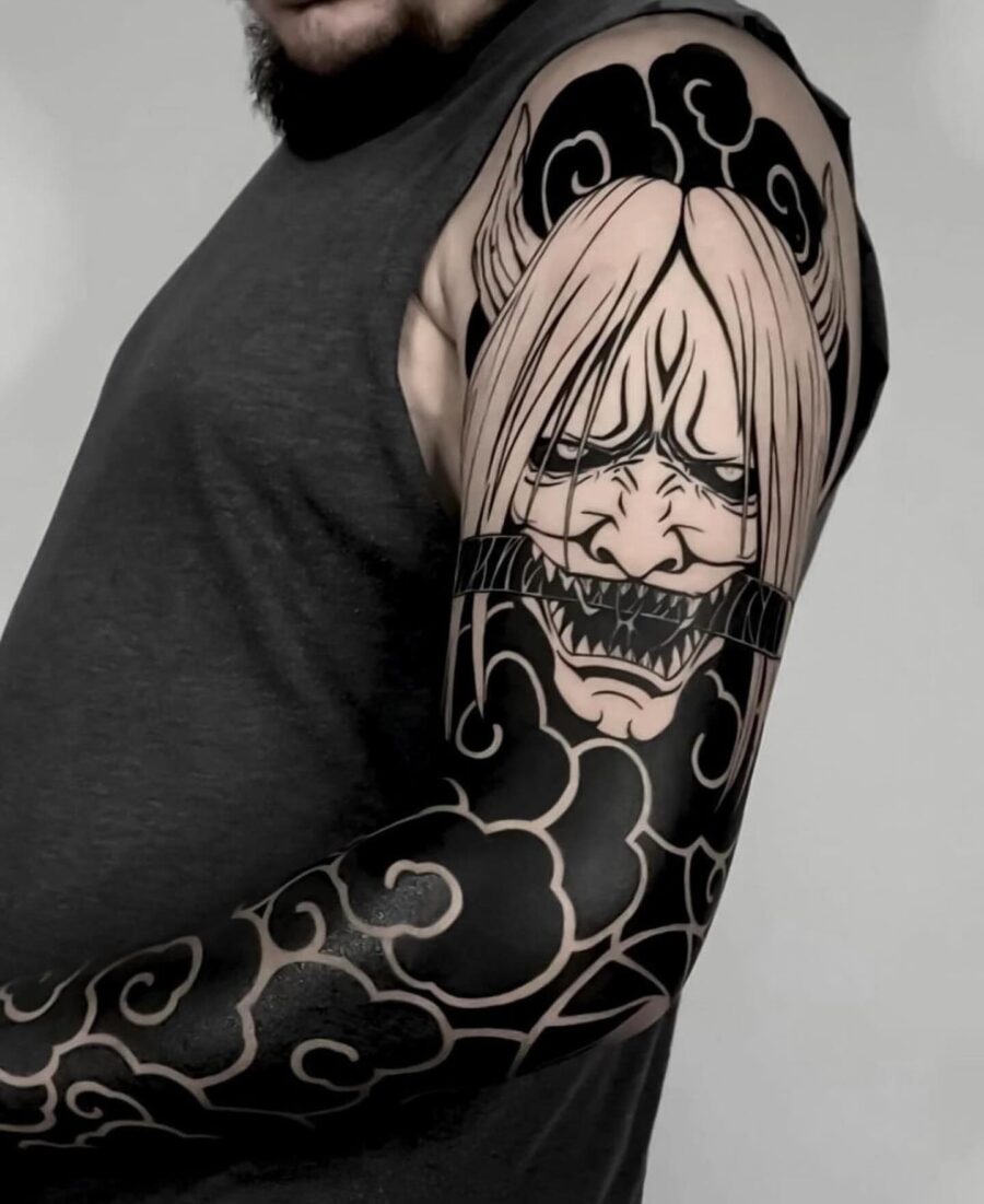 Dramatic character-inspired black sleeve tattoo