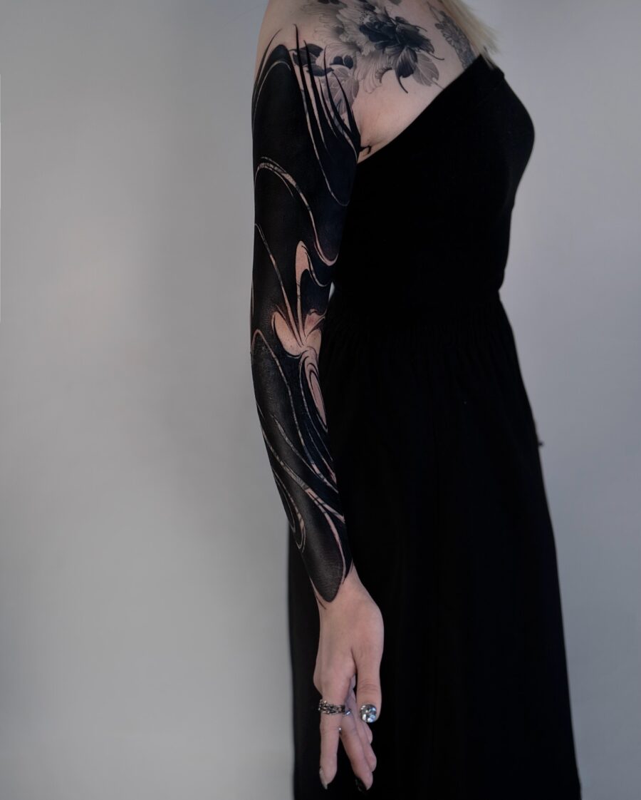 Sleek and bold black sleeve tattoo design