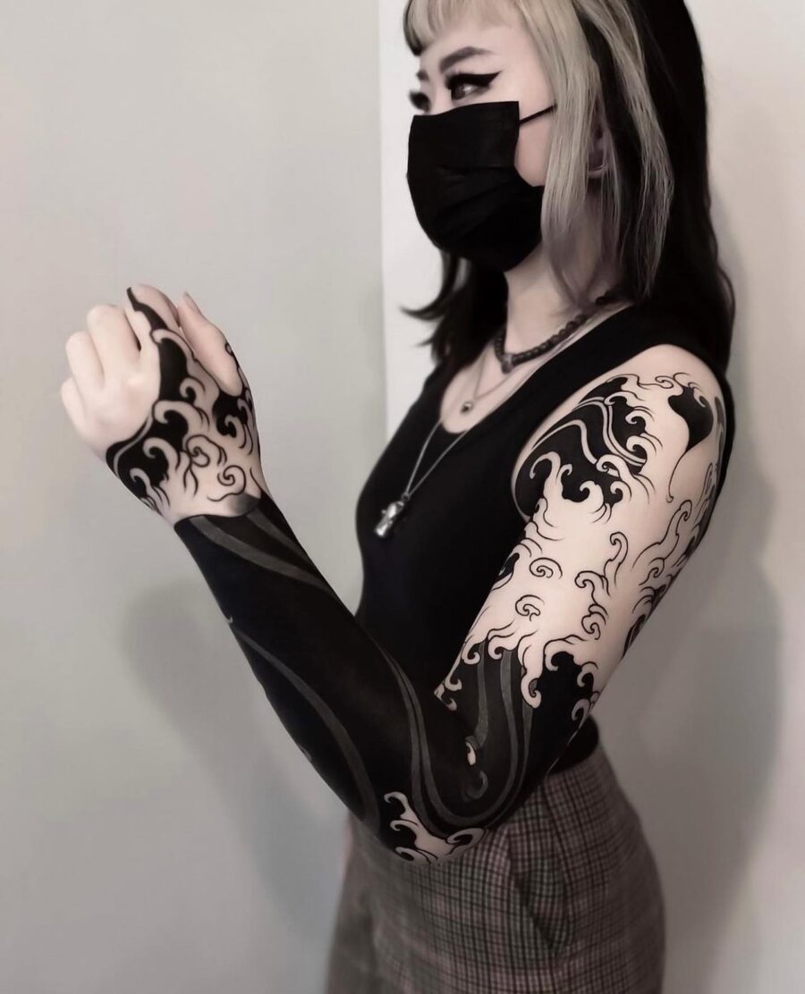 Elegant black sleeve tattoo with dynamic wave patterns