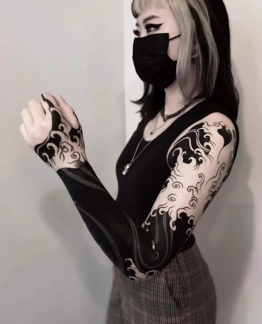 Elegant black sleeve tattoo with dynamic wave patterns