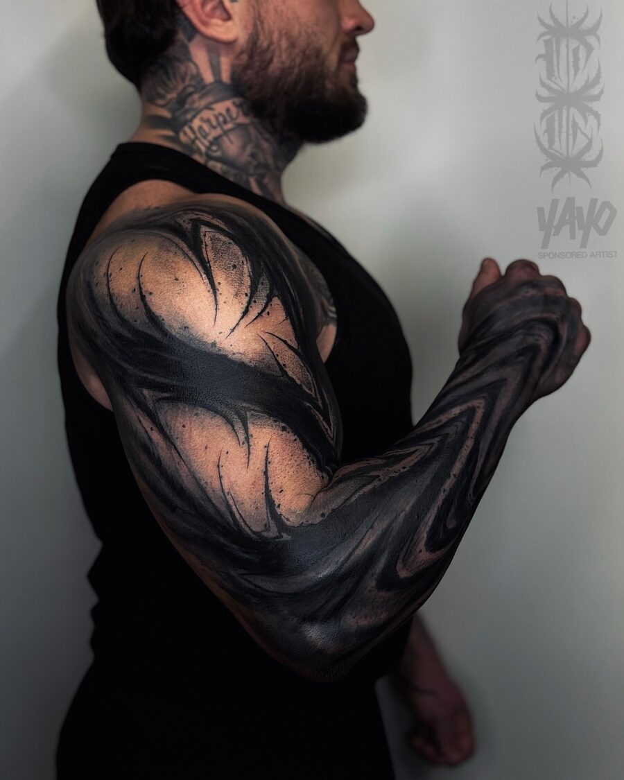 Bold and intricate black sleeve tattoo design