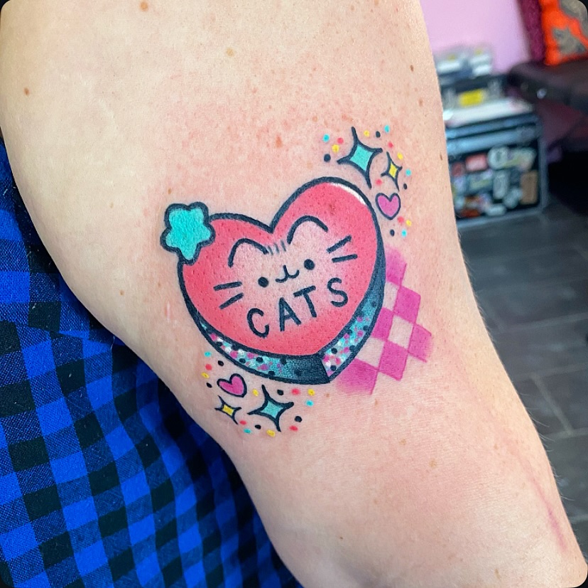 Whimsical Candy Heart Tattoo Featuring Adorable Cats