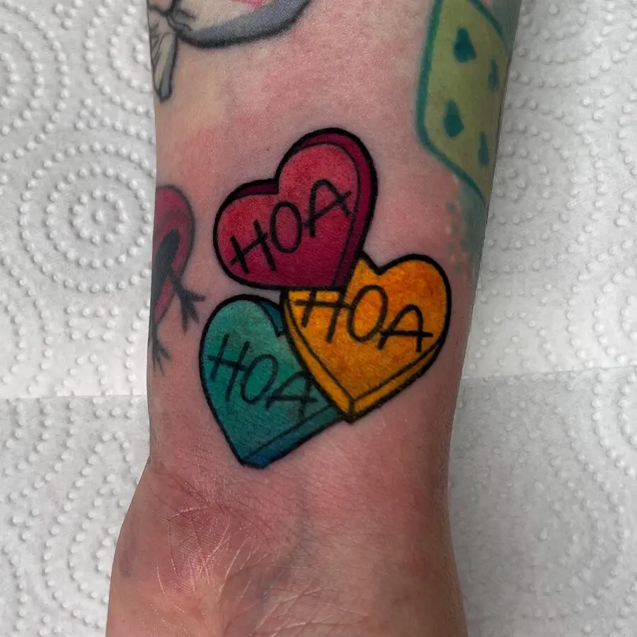 Playful candy heart tattoo with a sweet message