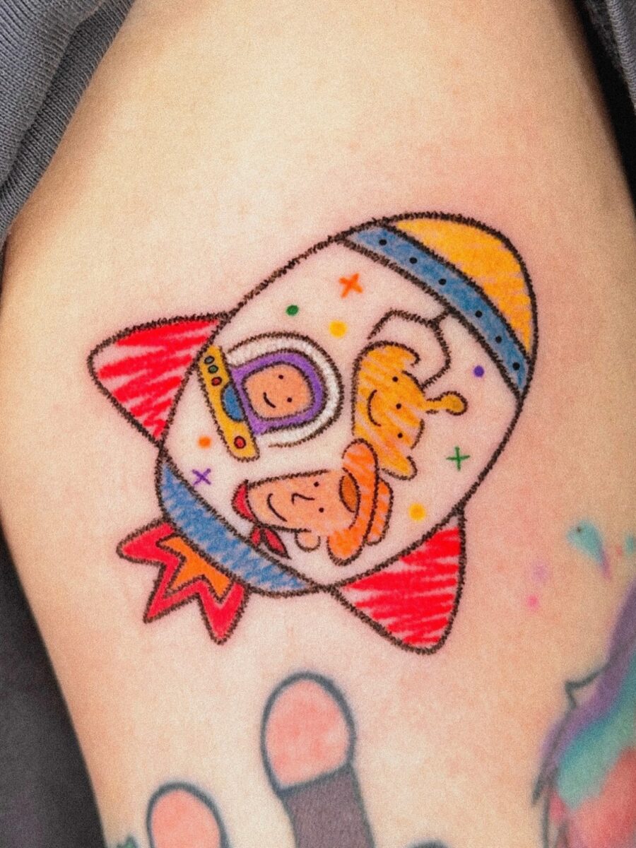 Playful Cartoon Astronaut Rocket Design Tattoo