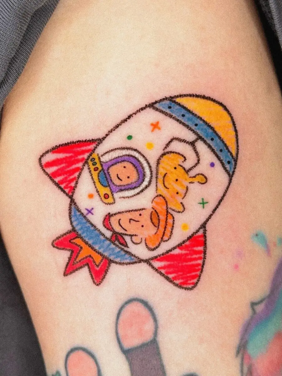 Playful Cartoon Astronaut Rocket Design Tattoo