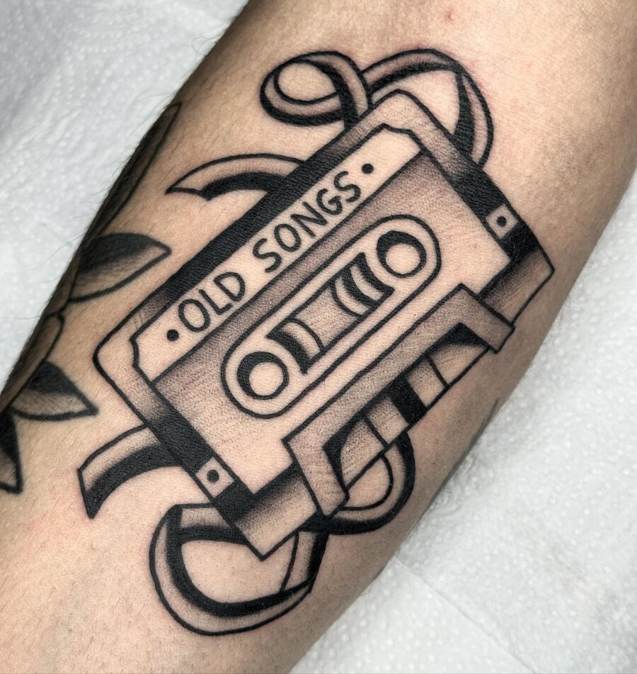 Nostalgic cassette tape tattoo featuring old songs
