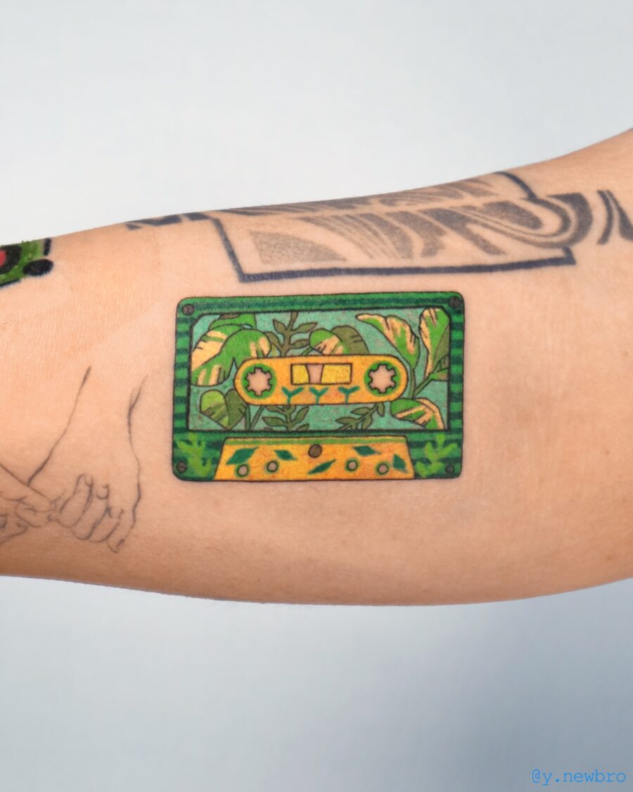Colorful cassette tattoo with lush plant details