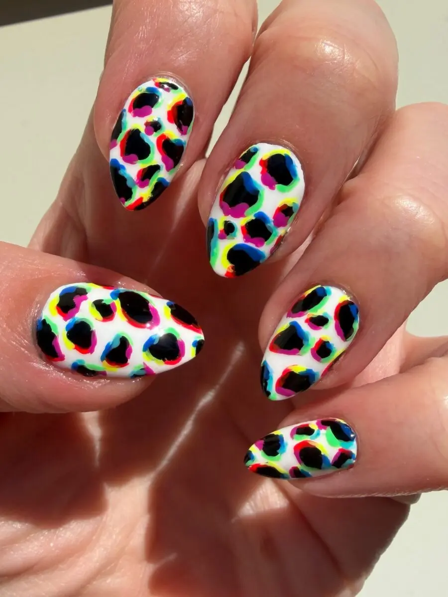 Vibrant cow print nail art on elegant hands