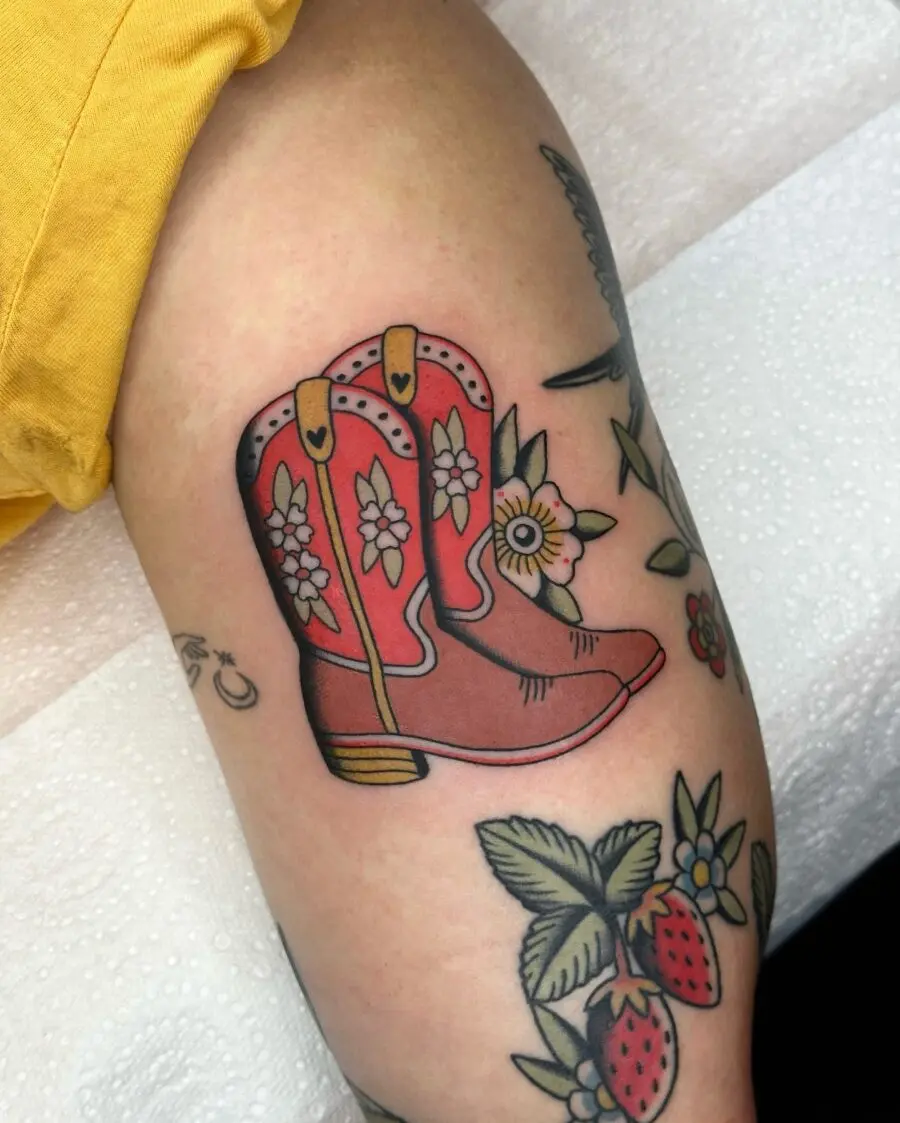 Vibrant cowboy boots tattoo with floral accents