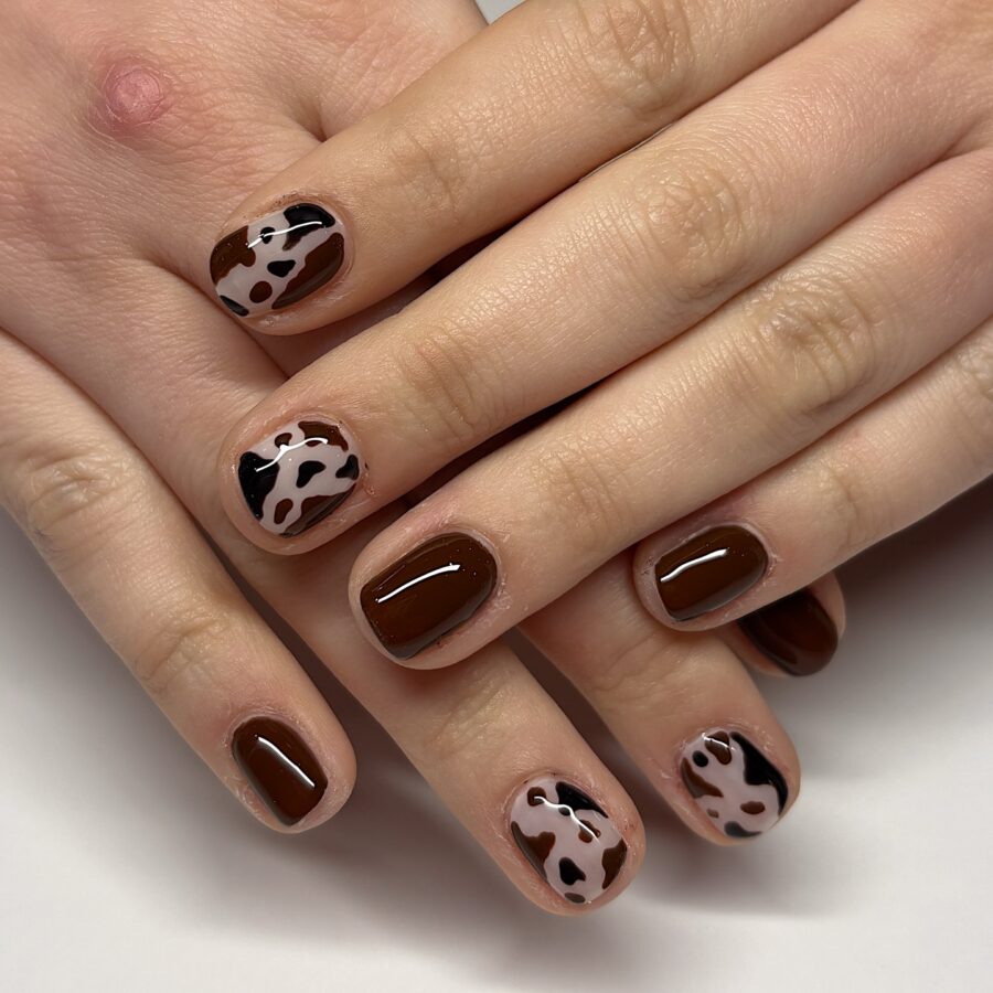 Chic cow print nail art with brown accents
