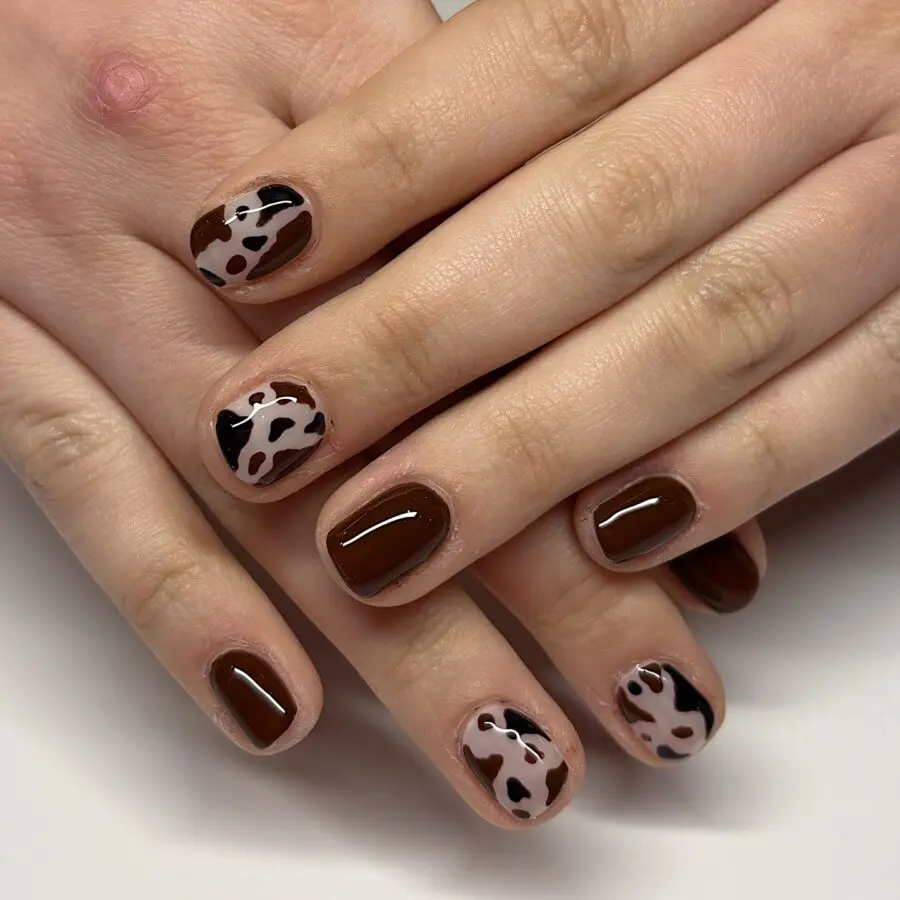 Chic cow print nail art with brown accents