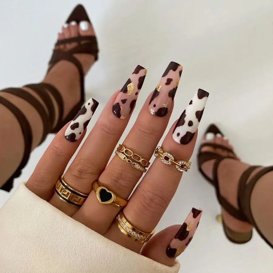 Chic cow print nails with elegant gold rings