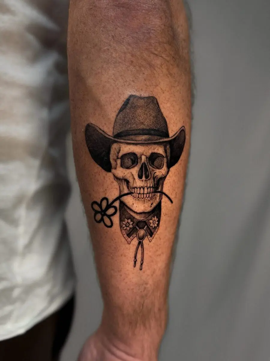 Classic cowboy skull tattoo with floral detail