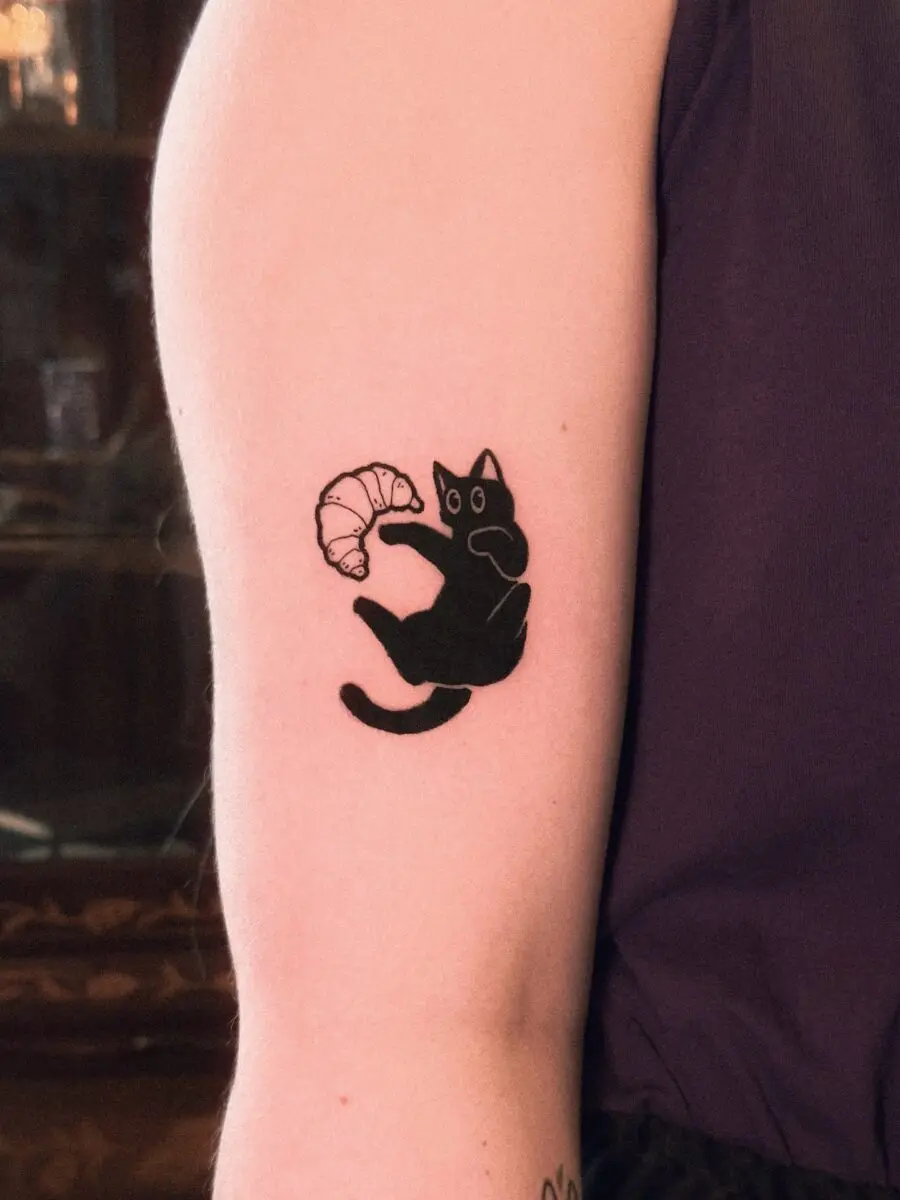 Charming cat with croissant tattoo design