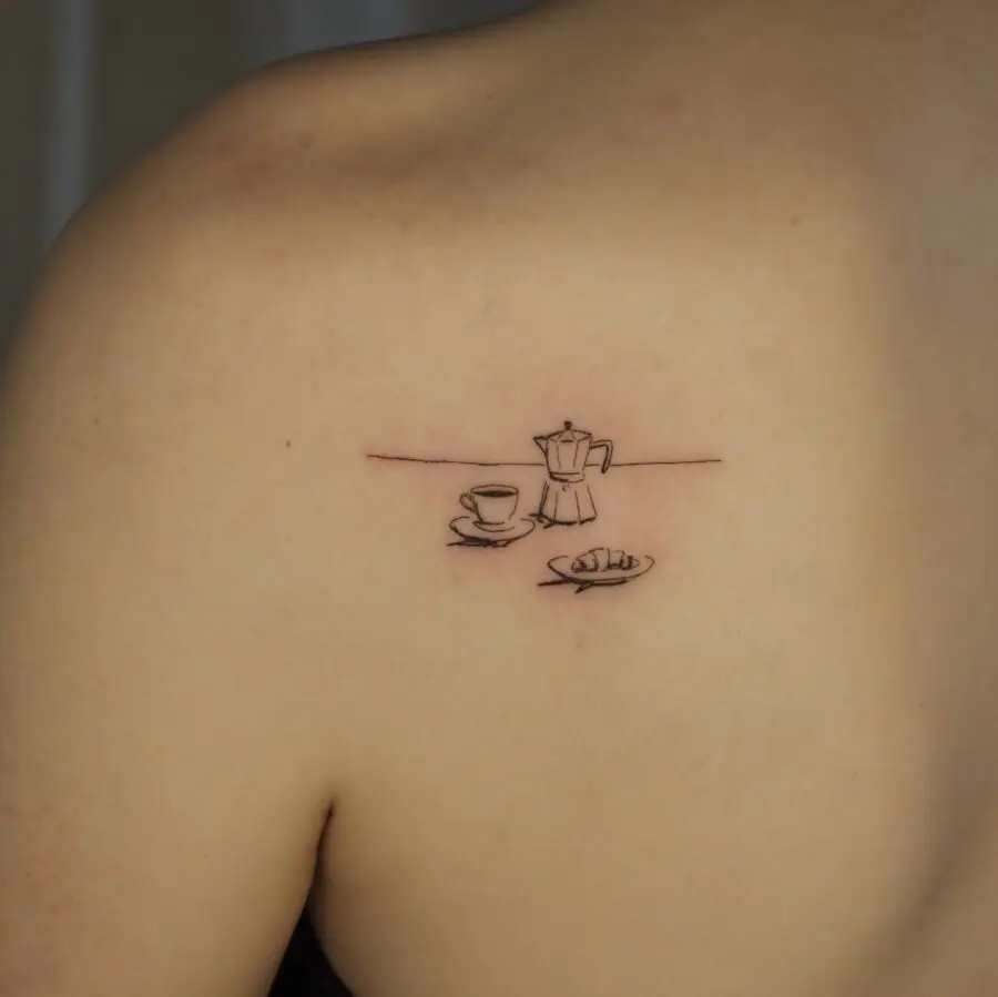 Charming croissant-inspired tattoo with coffee vibes