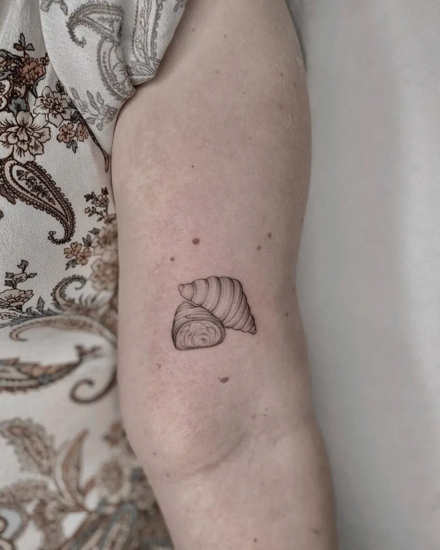 Charming croissant tattoo on a graceful arm