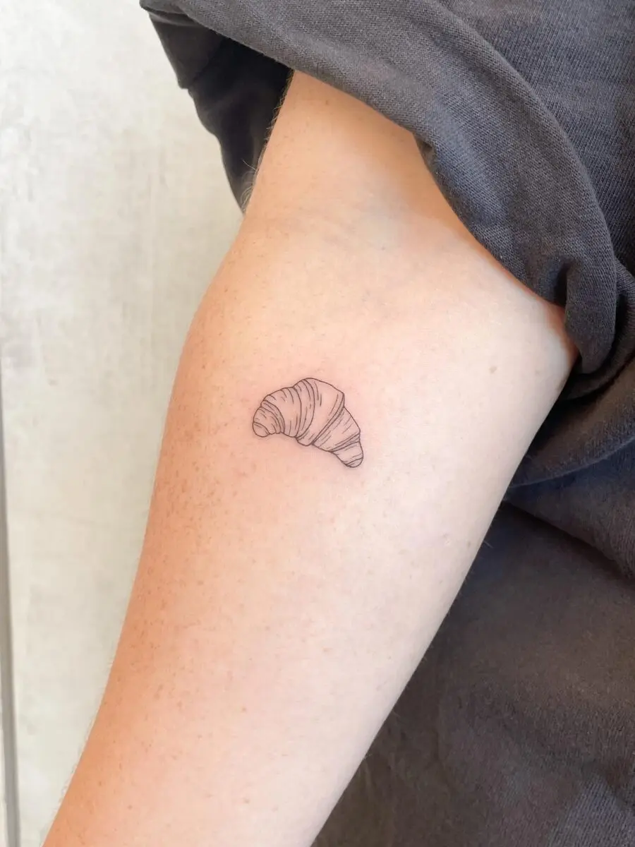 Delicate croissant tattoo on the forearm