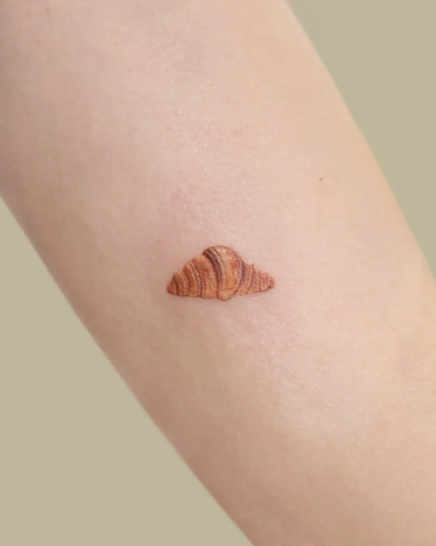 Charming croissant tattoo with realistic details