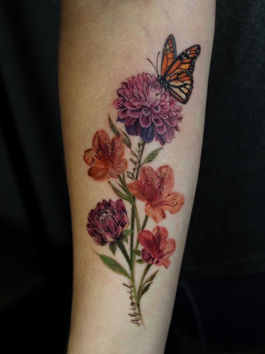 Beautiful dahlia tattoo with vibrant butterfly accents