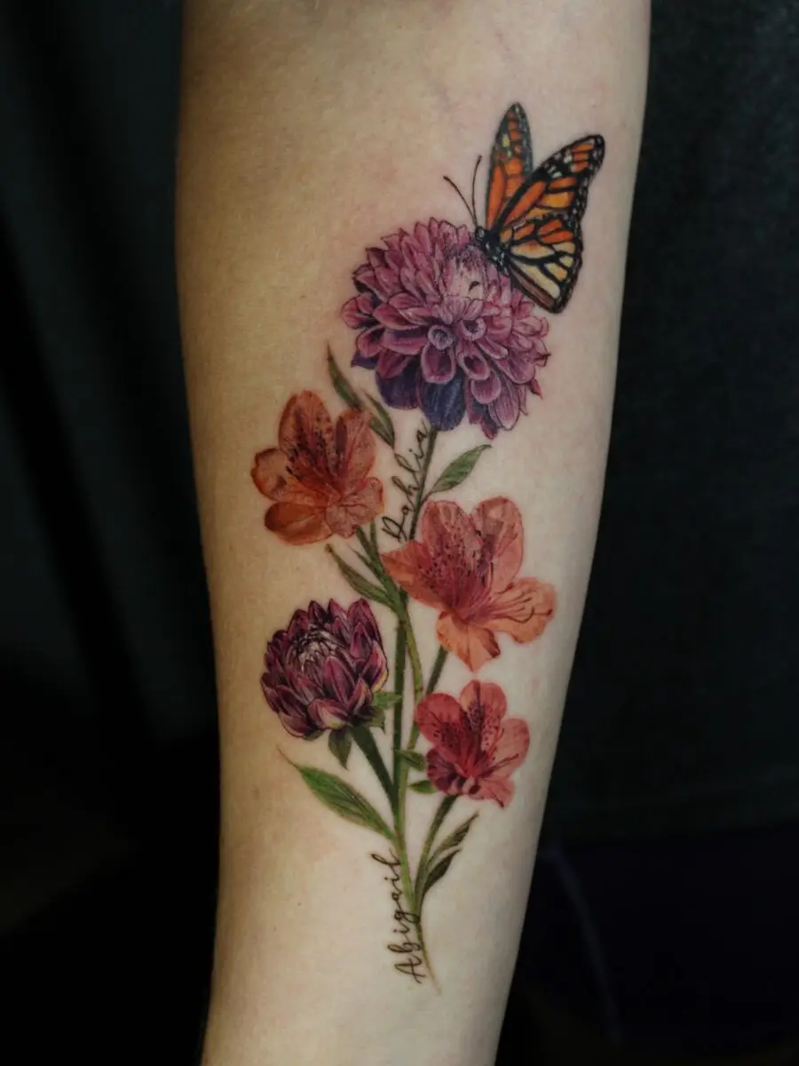 Beautiful dahlia tattoo with vibrant butterfly accents