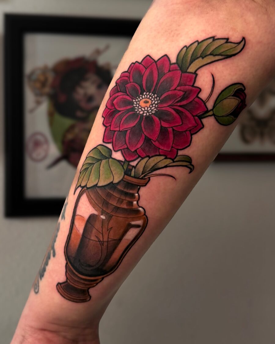 Vibrant dahlia tattoo in a vase design