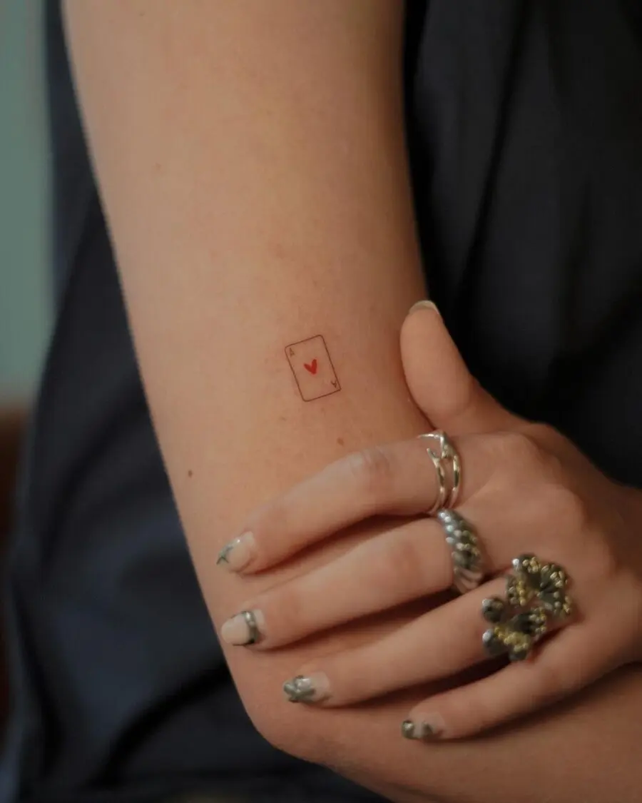 Minimalist heart card tattoo on the arm
