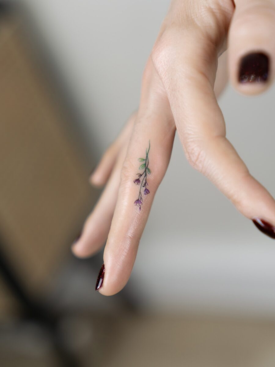 Delicate flower tattoo on fingertip