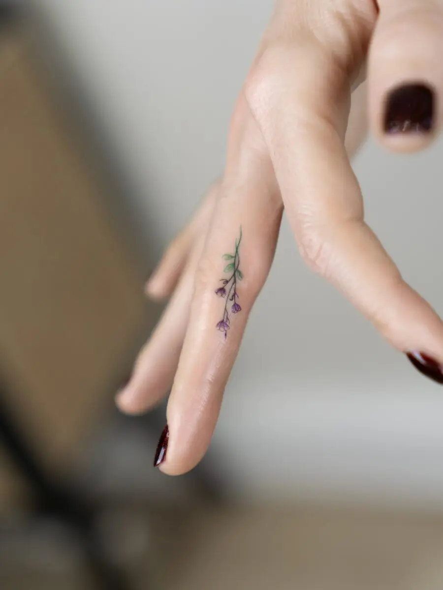 Delicate flower tattoo on fingertip