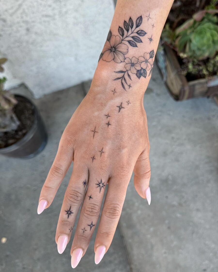 Elegant floral and star hand tattoos