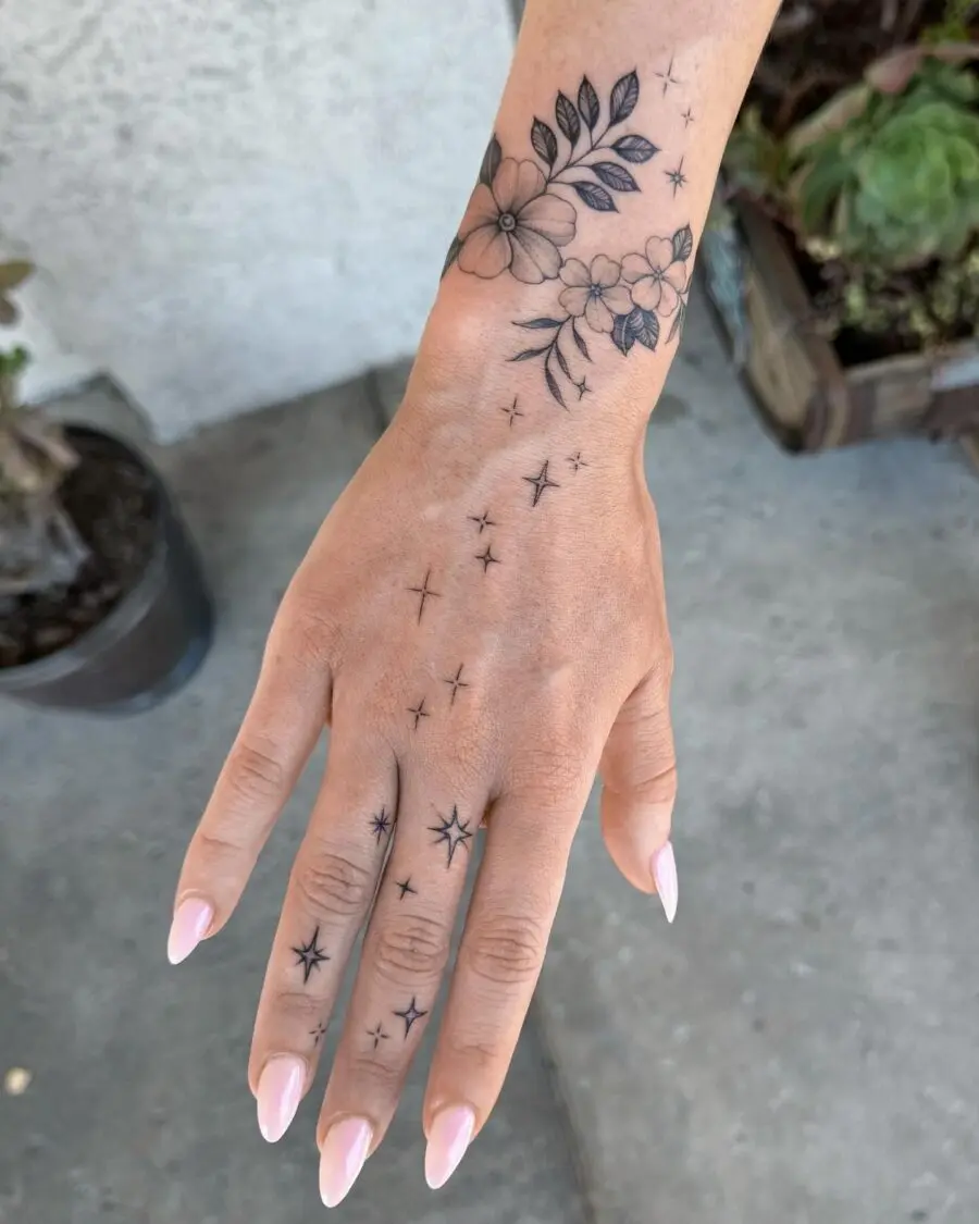 Elegant floral and star hand tattoos