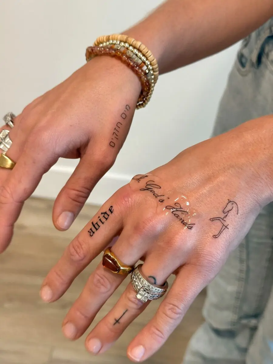 Elegant dainty tattoos adorn stylish hands