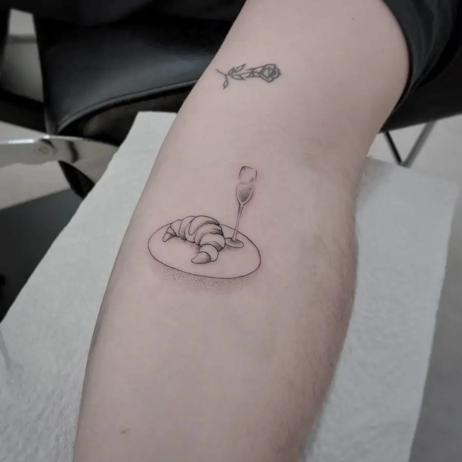Charming croissant tattoo with a sparkling touch