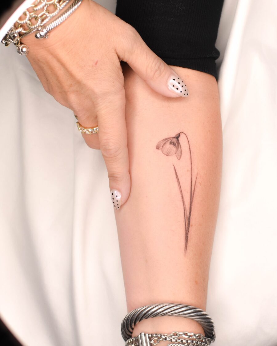 Elegant snowdrop flower tattoo on forearm