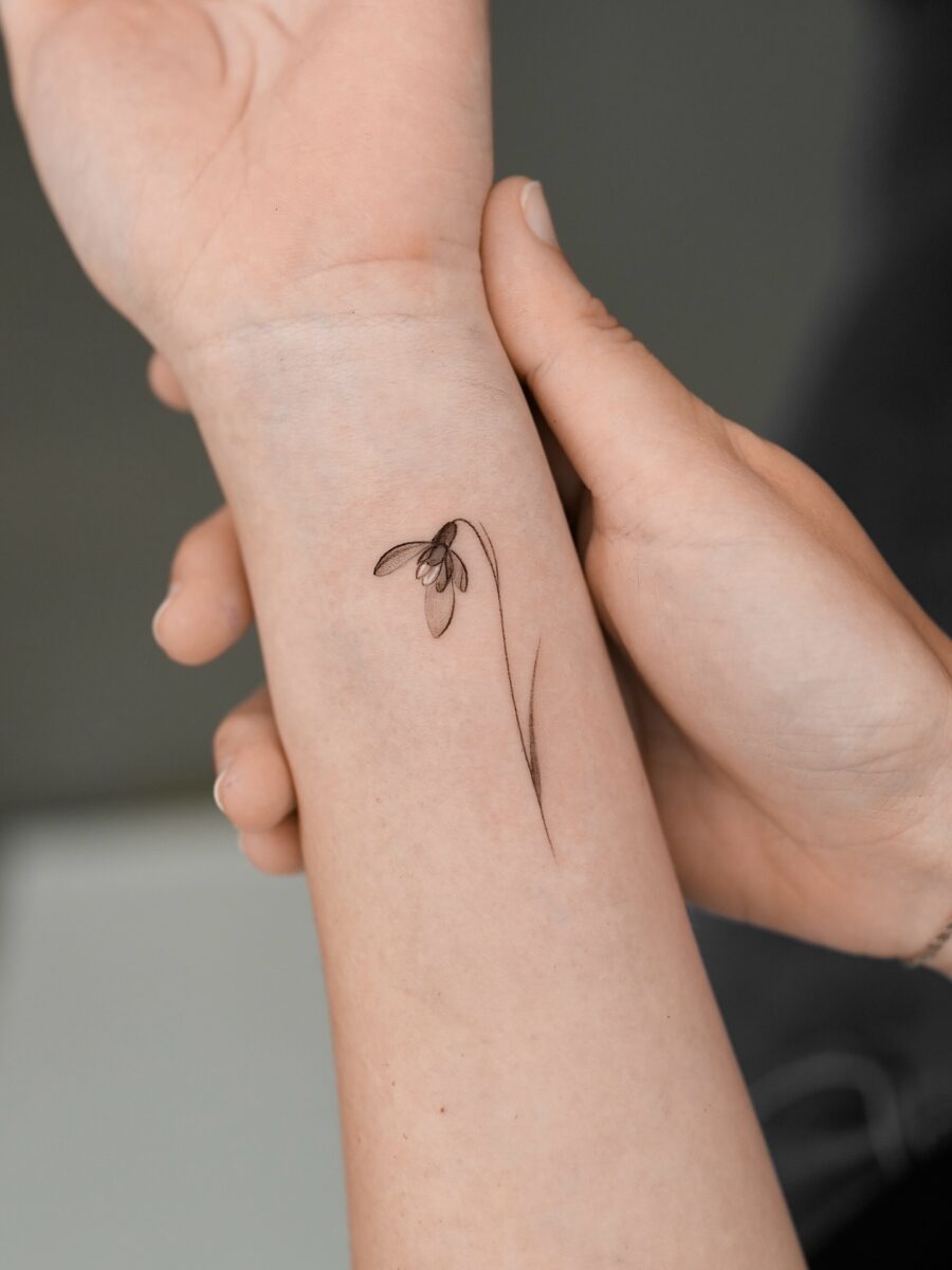 Delicate snowdrop tattoo on the forearm