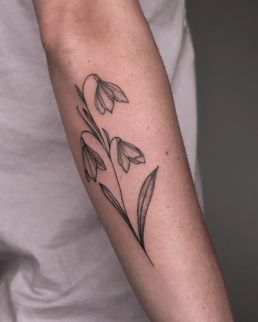 Elegant snowdrop flower tattoo on forearm