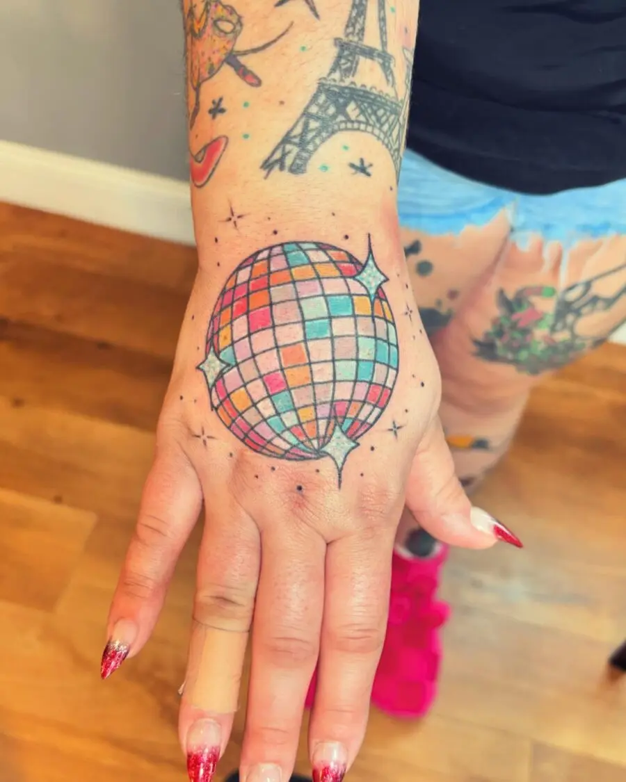Vibrant disco ball tattoo on the hand