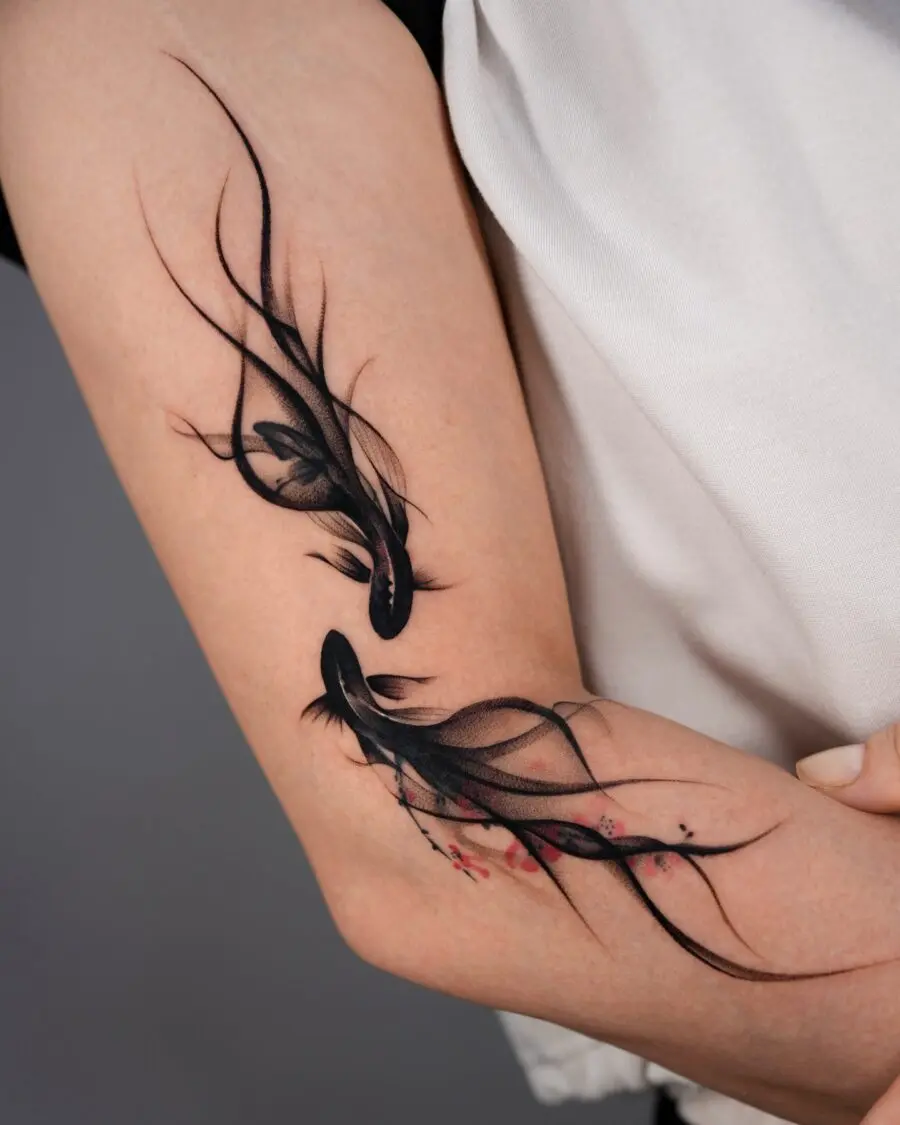 Graceful black fish tattoos with floral accents