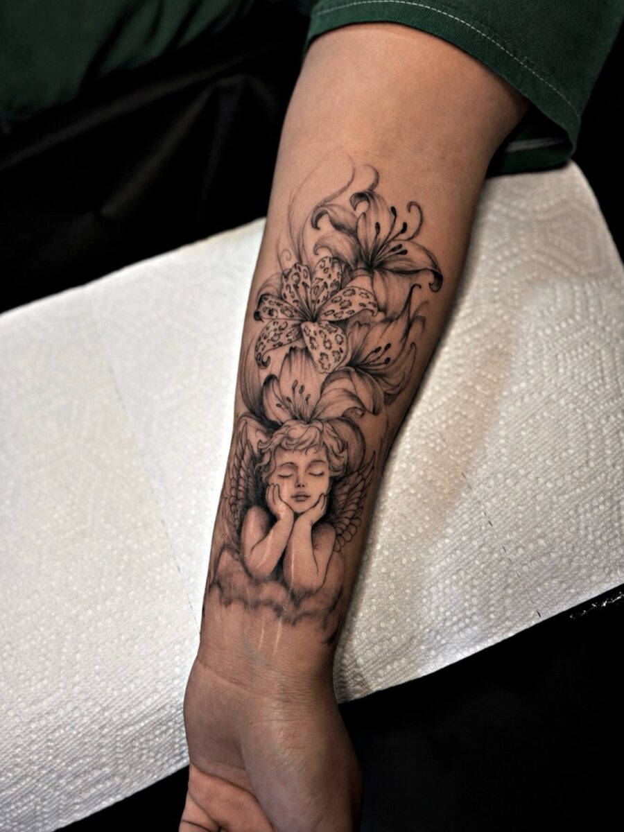 Delicate angel and floral half sleeve tattoo
