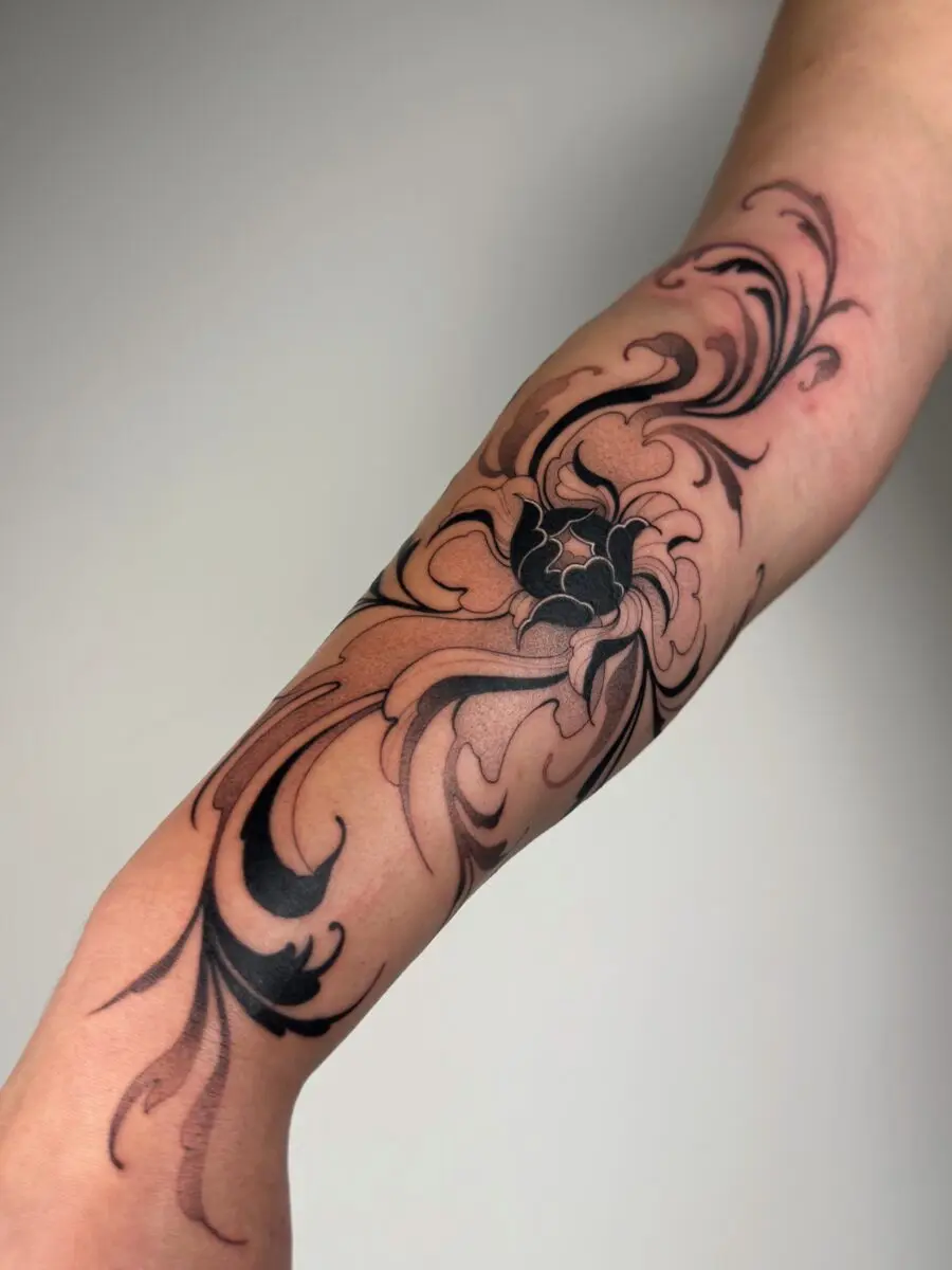 Elegantly swirling black floral tattoo design