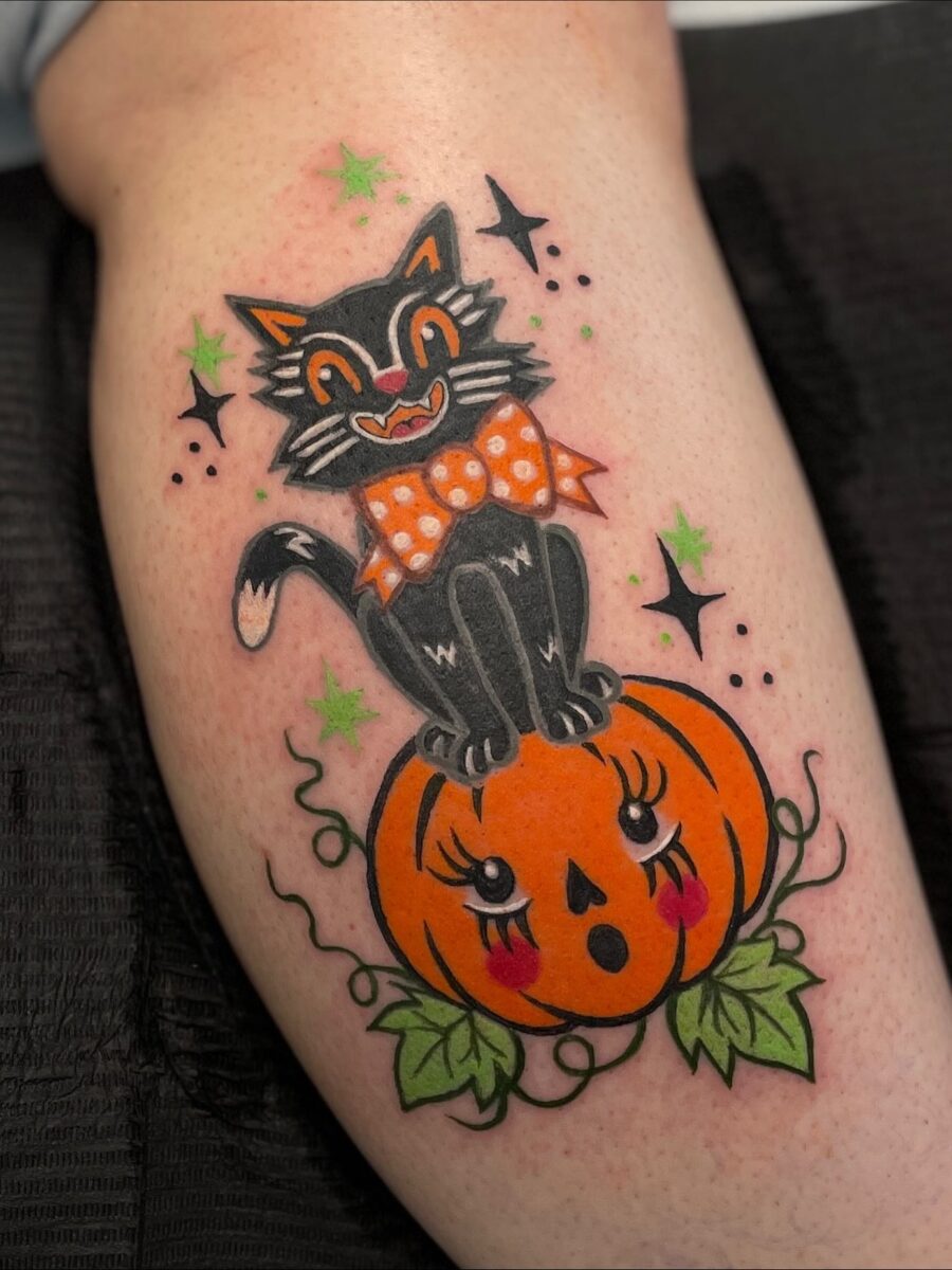 Whimsical black cat atop a pumpkin tattoo
