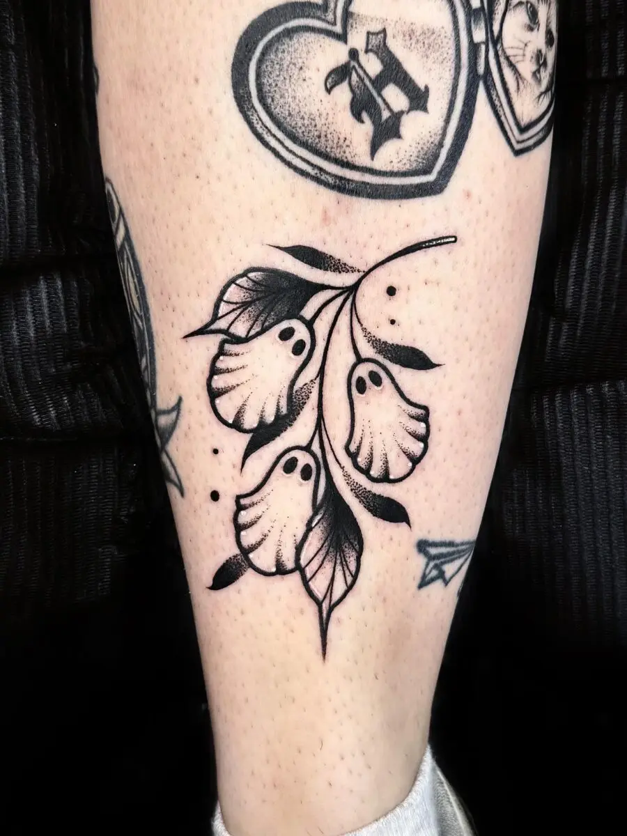 Eerie flora with ghostly elements in tattoo art