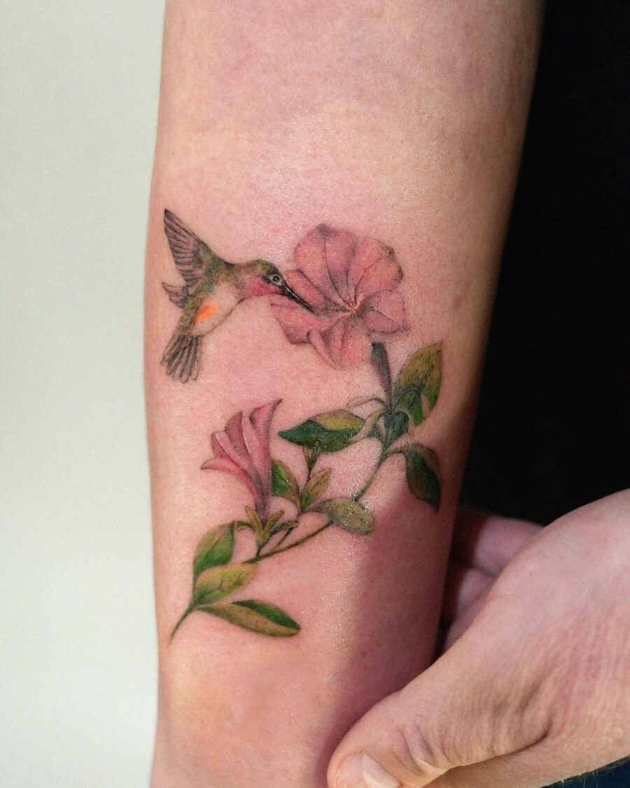 Vibrant petunia tattoo with hummingbird depiction